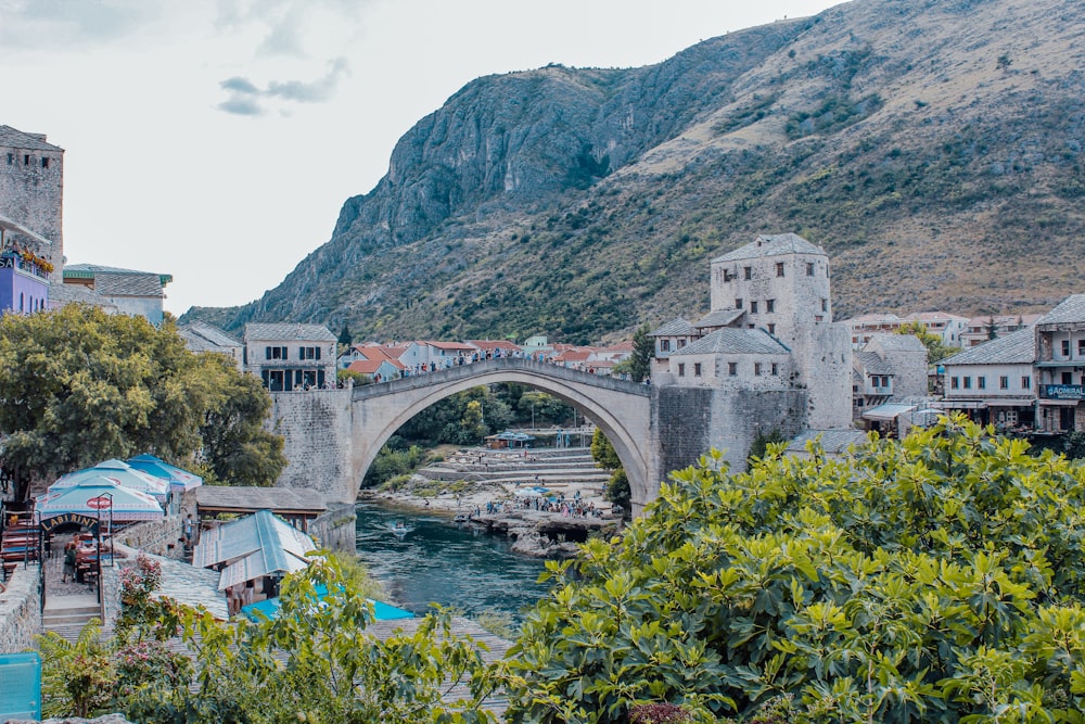 Un puente de piedra sobre un río junto a una exuberante ladera verde