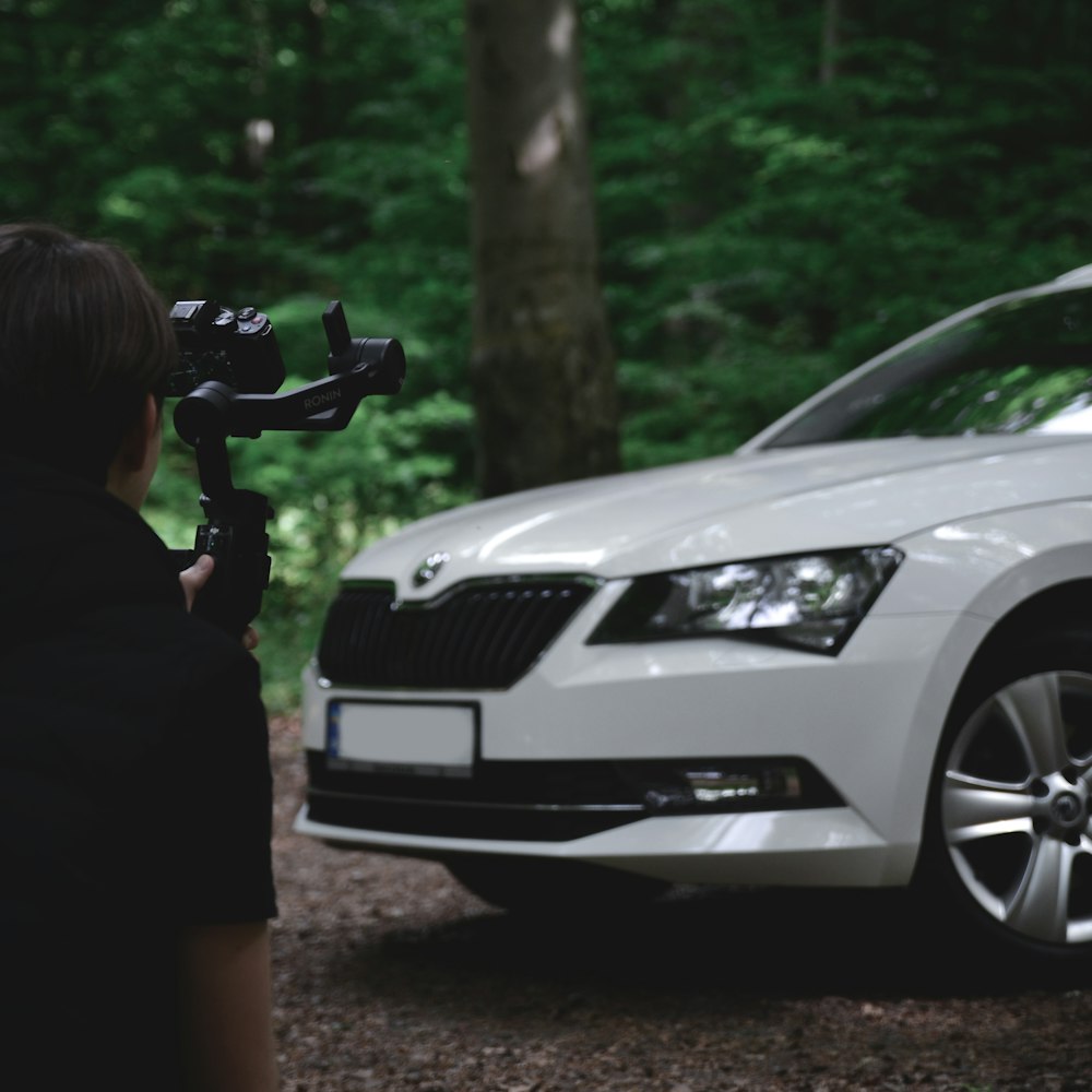 Une personne filme une voiture dans les bois