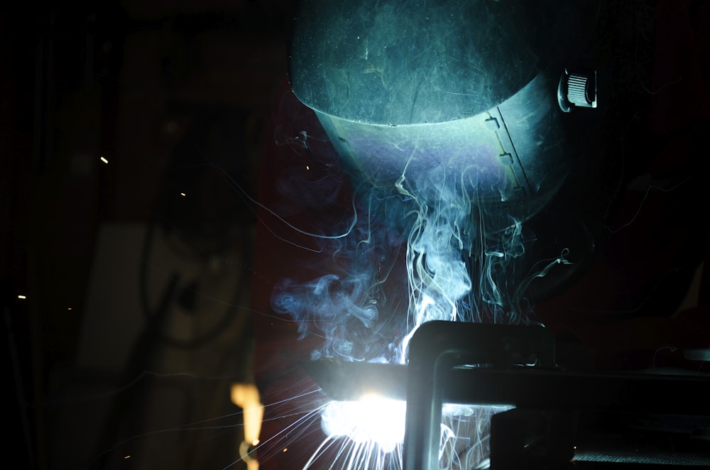 welder working on a piece of metal in the dark
