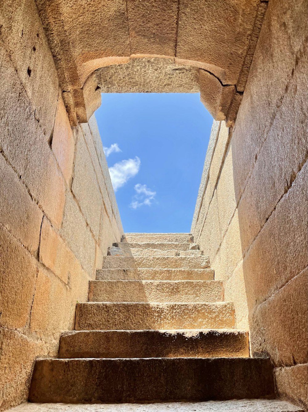 a stone staircase leading up to a blue sky