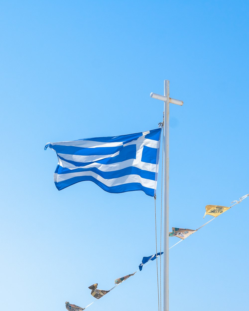 a blue and white flag flying next to a cross