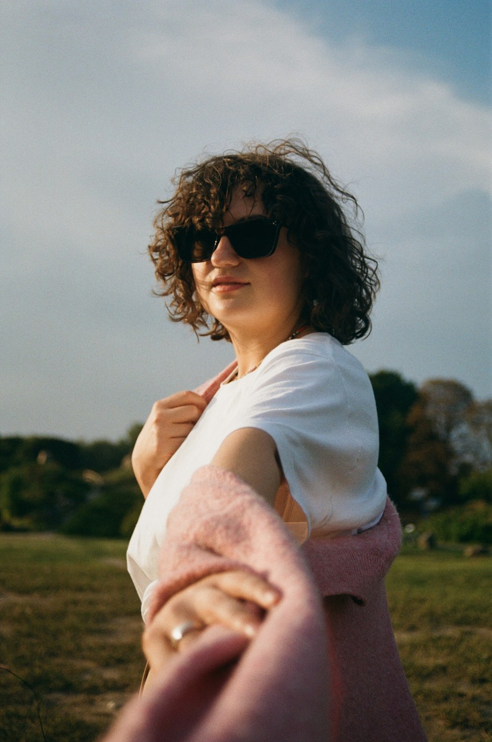 a woman wearing sunglasses and a pink blanket