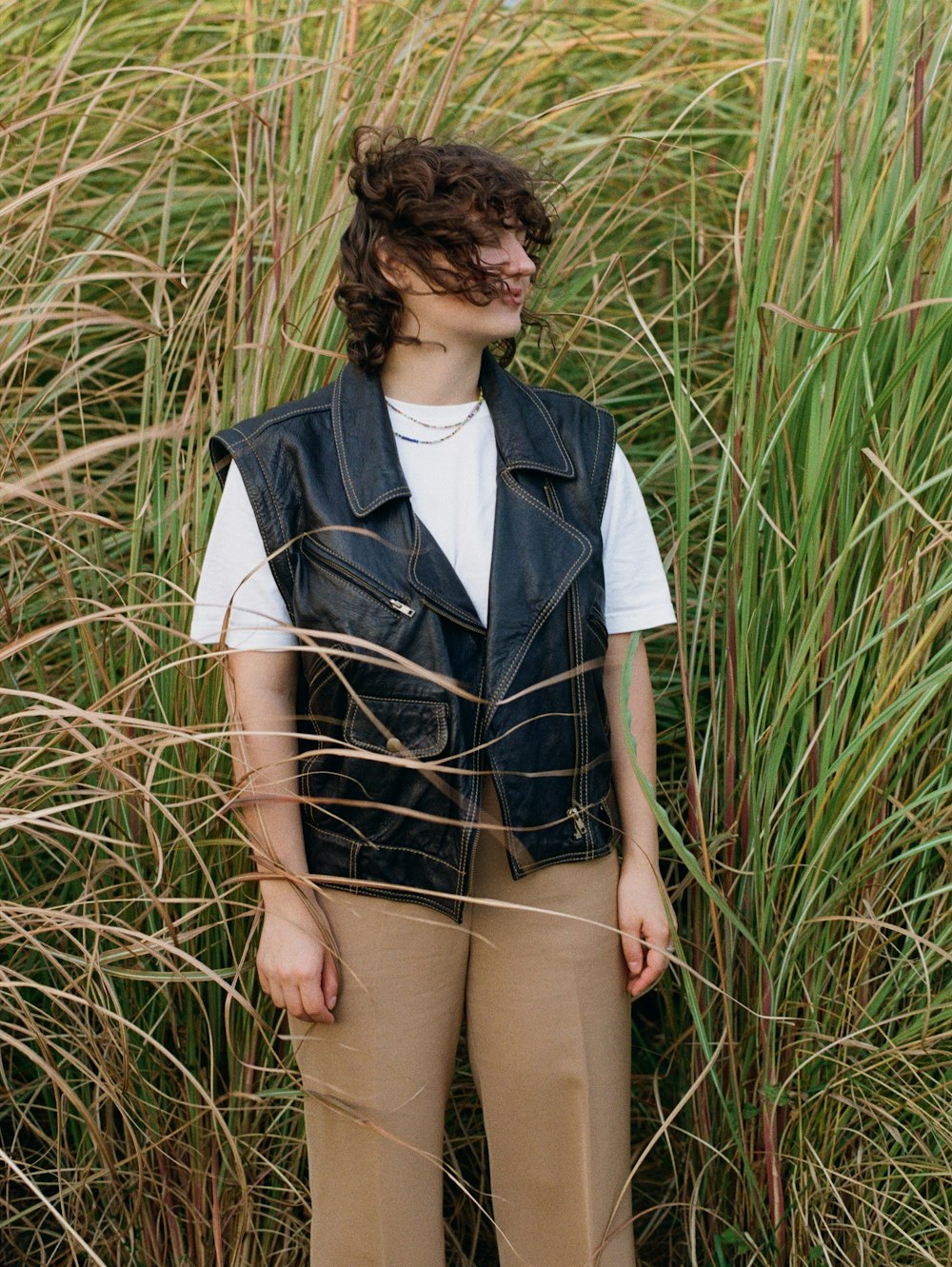 a woman standing in a field of tall grass