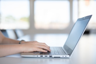 a close up of a person typing on a laptop
