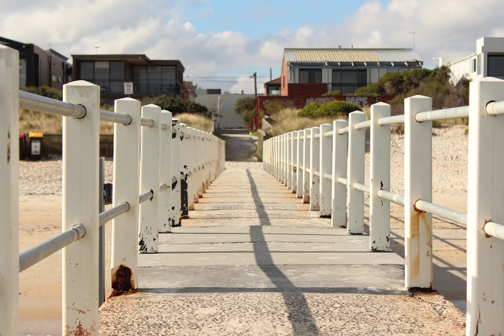 a long white fence with a building in the background