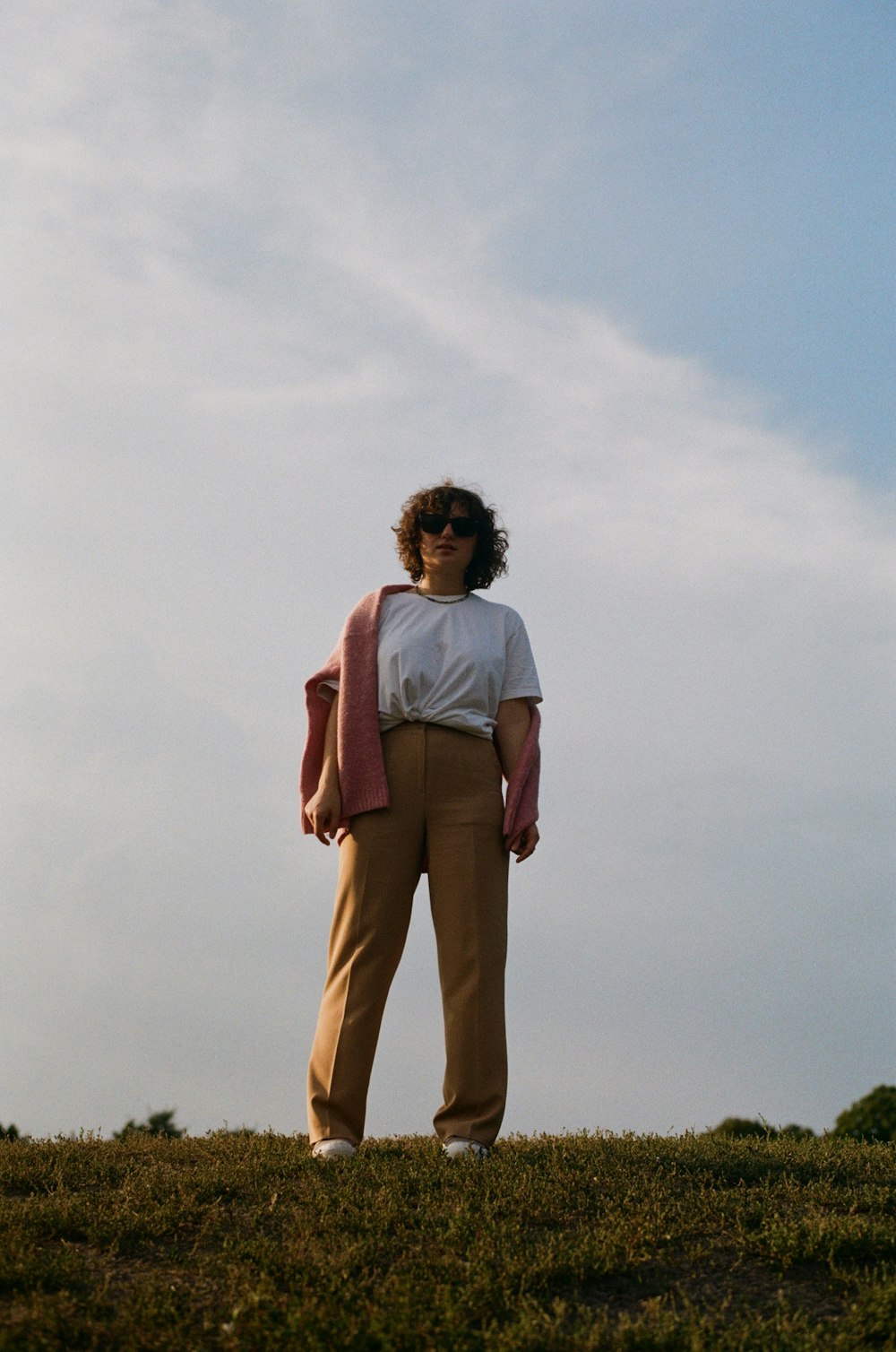 a man standing on top of a grass covered field