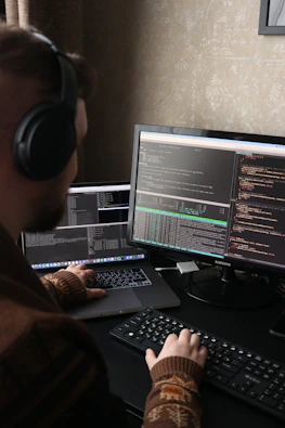 a man sitting at a computer with headphones on