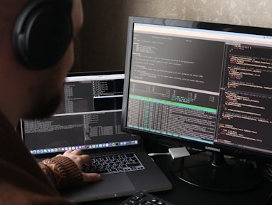 a man sitting at a computer with headphones on