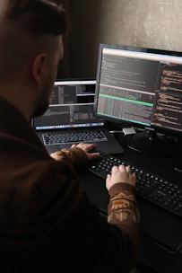 a man sitting in front of a computer on a desk