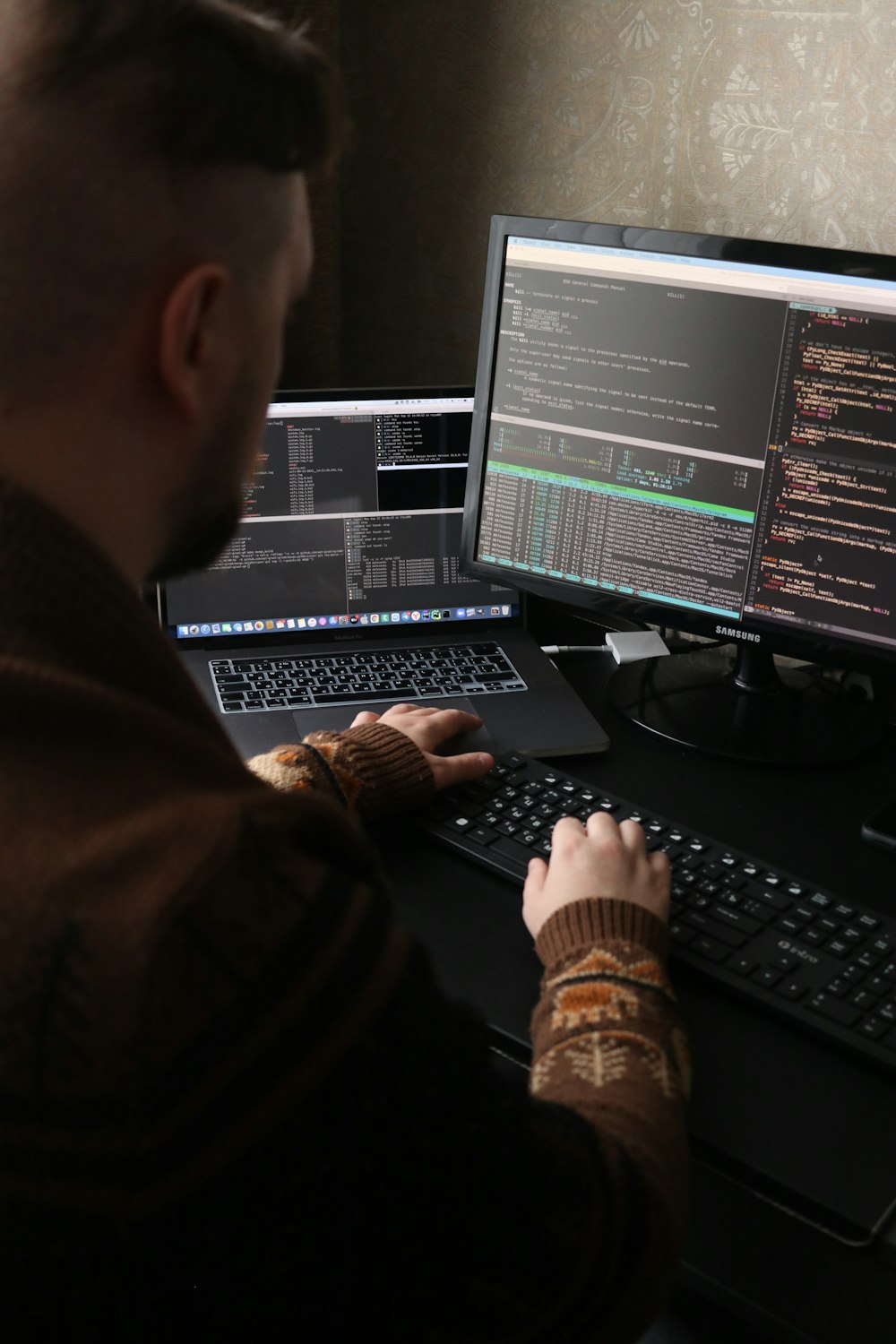 Un homme assis devant un ordinateur sur un bureau