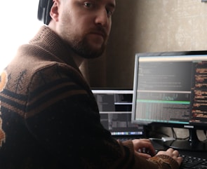 a man sitting at a computer with headphones on