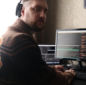 a man sitting at a computer with headphones on