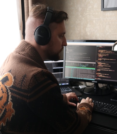 a man wearing headphones sitting in front of a computer