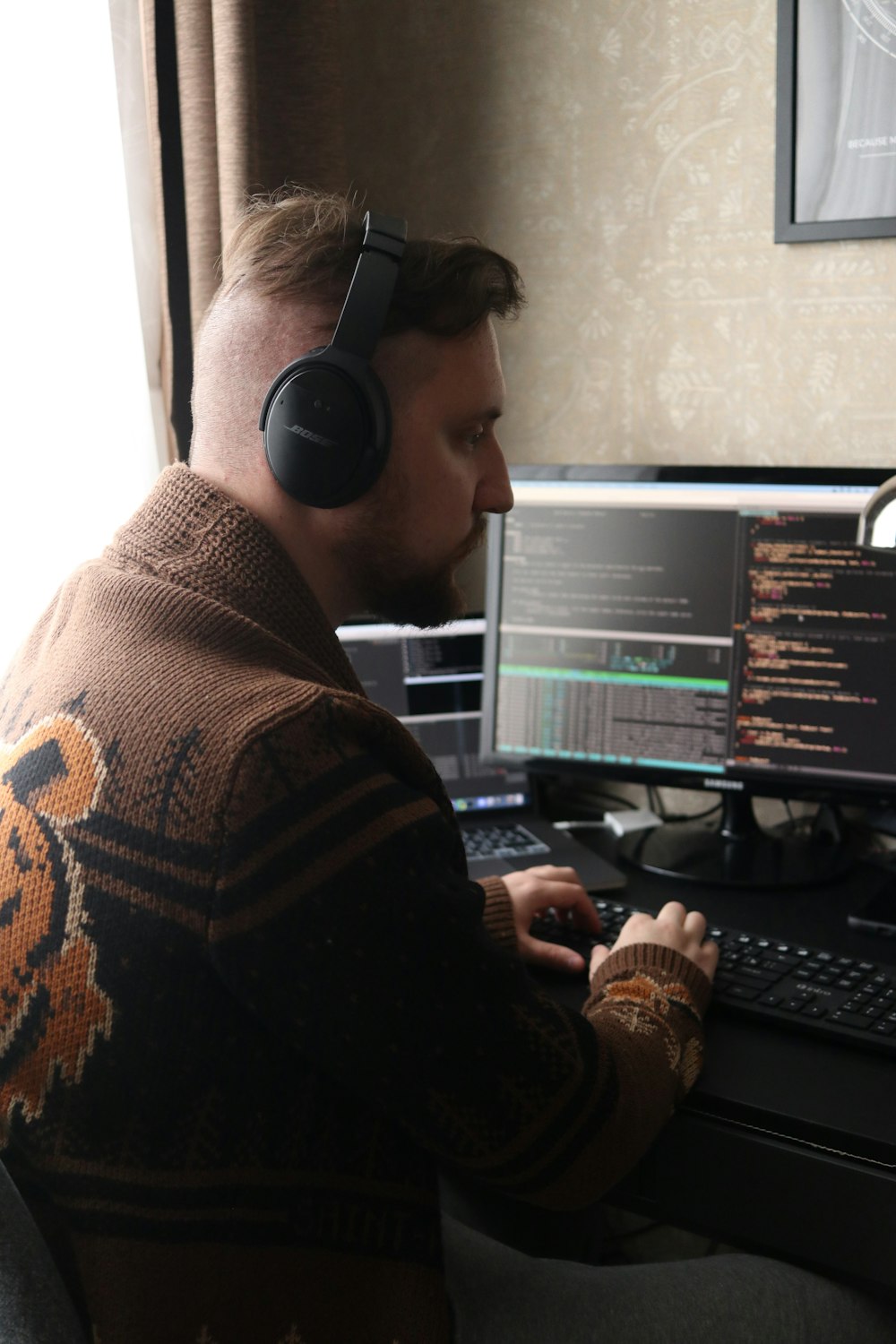 a man wearing headphones sitting in front of a computer