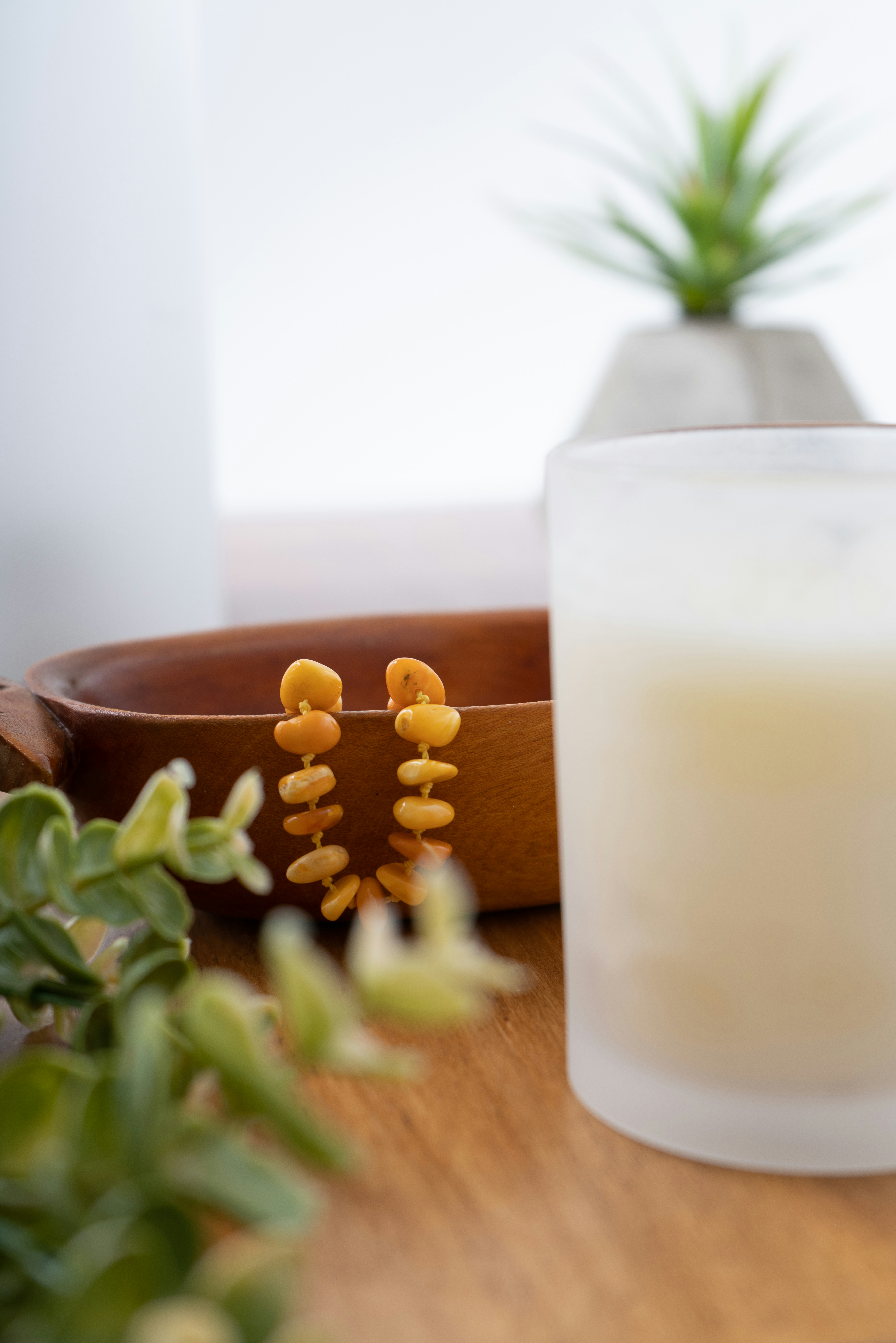 a candle sitting on a table next to a potted plant
