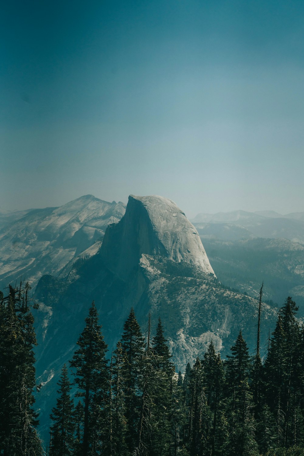 a view of a mountain with trees in the foreground