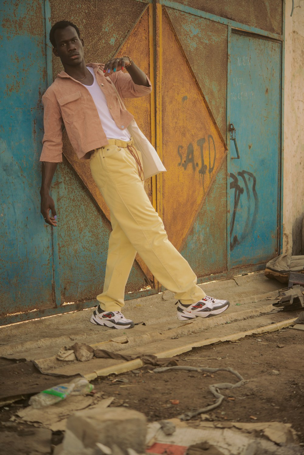 Un uomo in pantaloni gialli appoggiato a un muro foto – Africano Immagine  gratuita su Unsplash