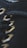 Close-up of black fabric with metallic eyelets threaded with a black cord, showcasing detailed stitching and texture.