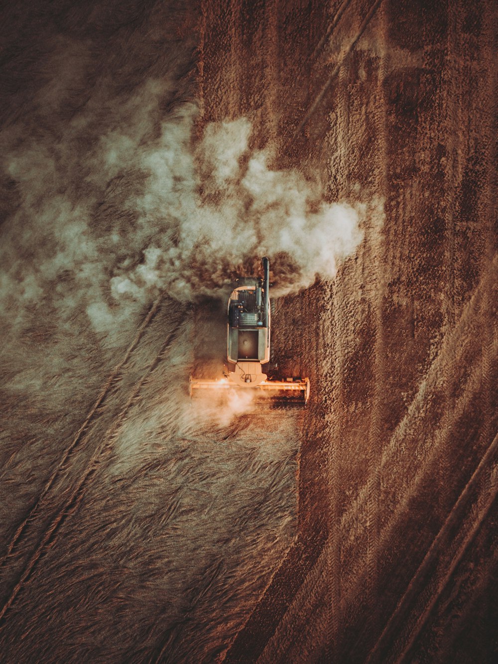 an aerial view of a tractor plowing a field