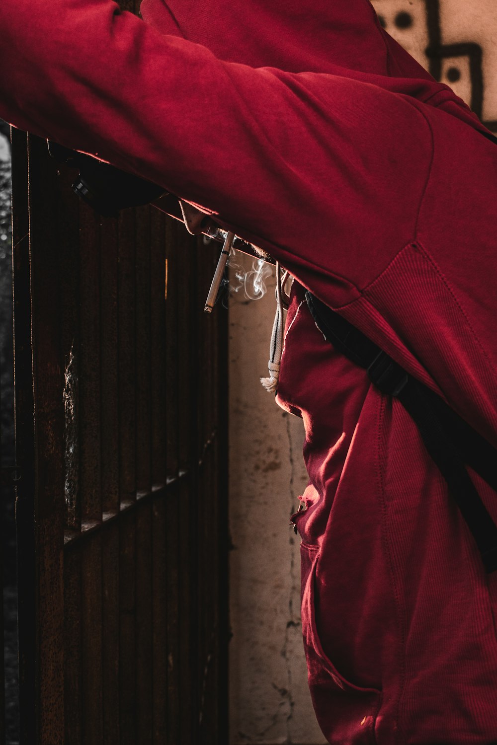 a person wearing a red jacket and smoking a cigarette