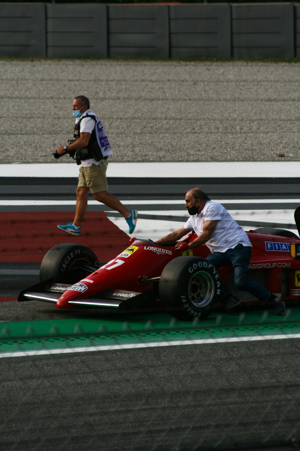 a man is pushing a race car on the track