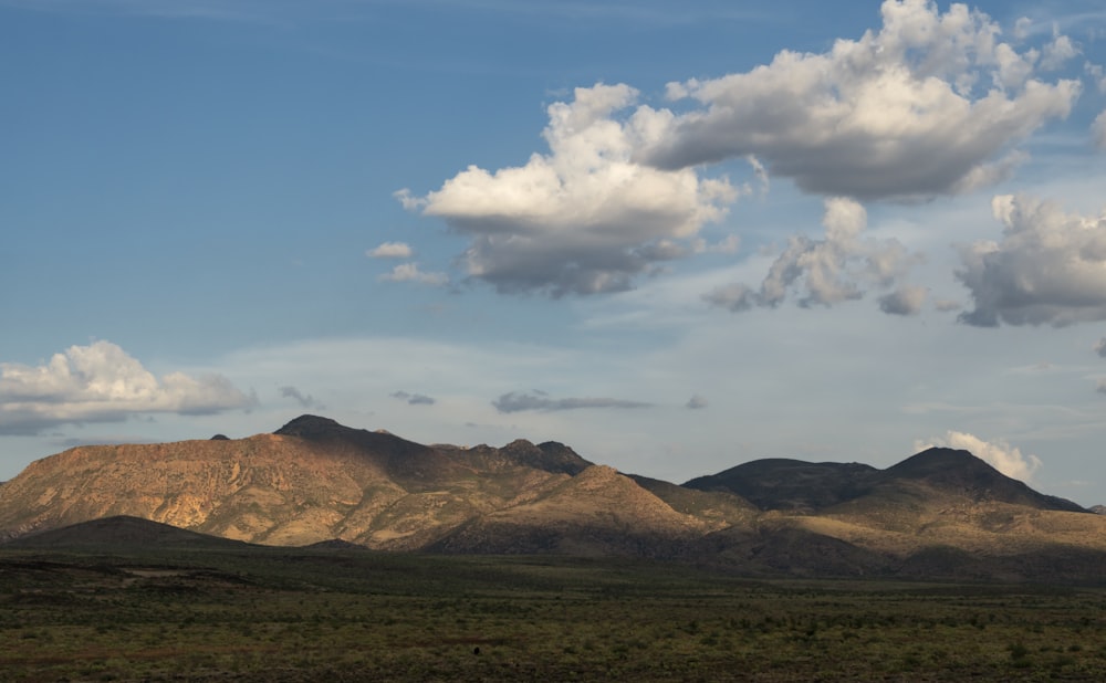 uma cordilheira com algumas nuvens no céu