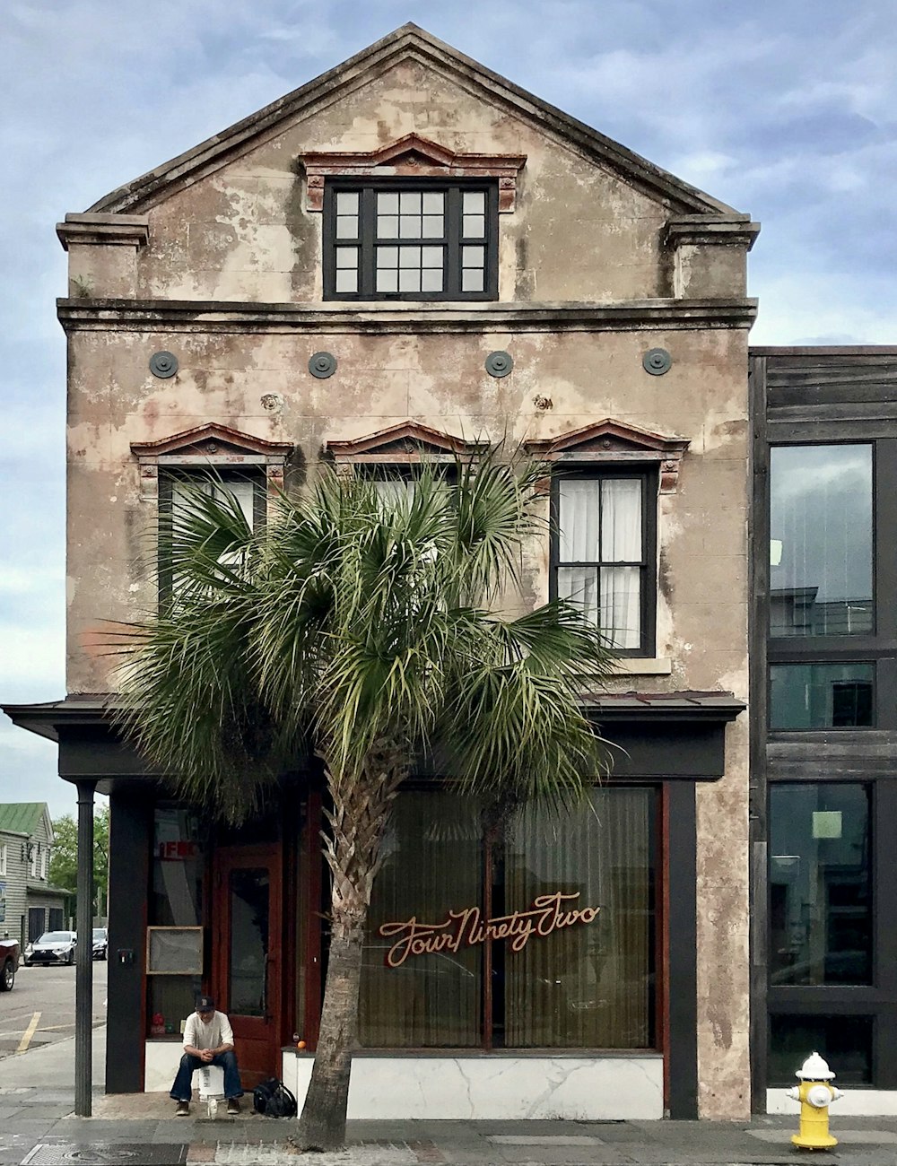 a tall building with a palm tree in front of it