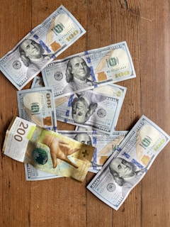 a bunch of money sitting on top of a wooden table