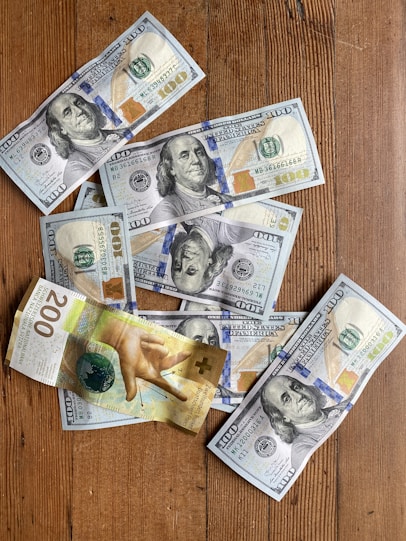 a bunch of money sitting on top of a wooden table