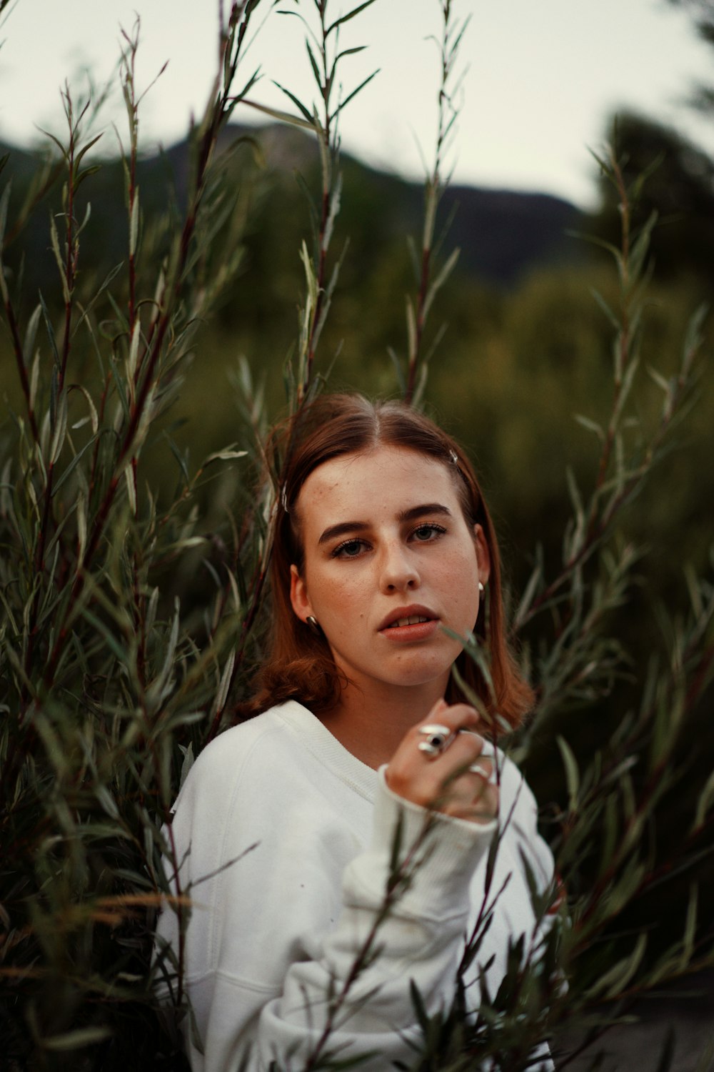 a woman standing in a field of tall grass