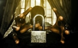 a person holding a padlock in front of a window