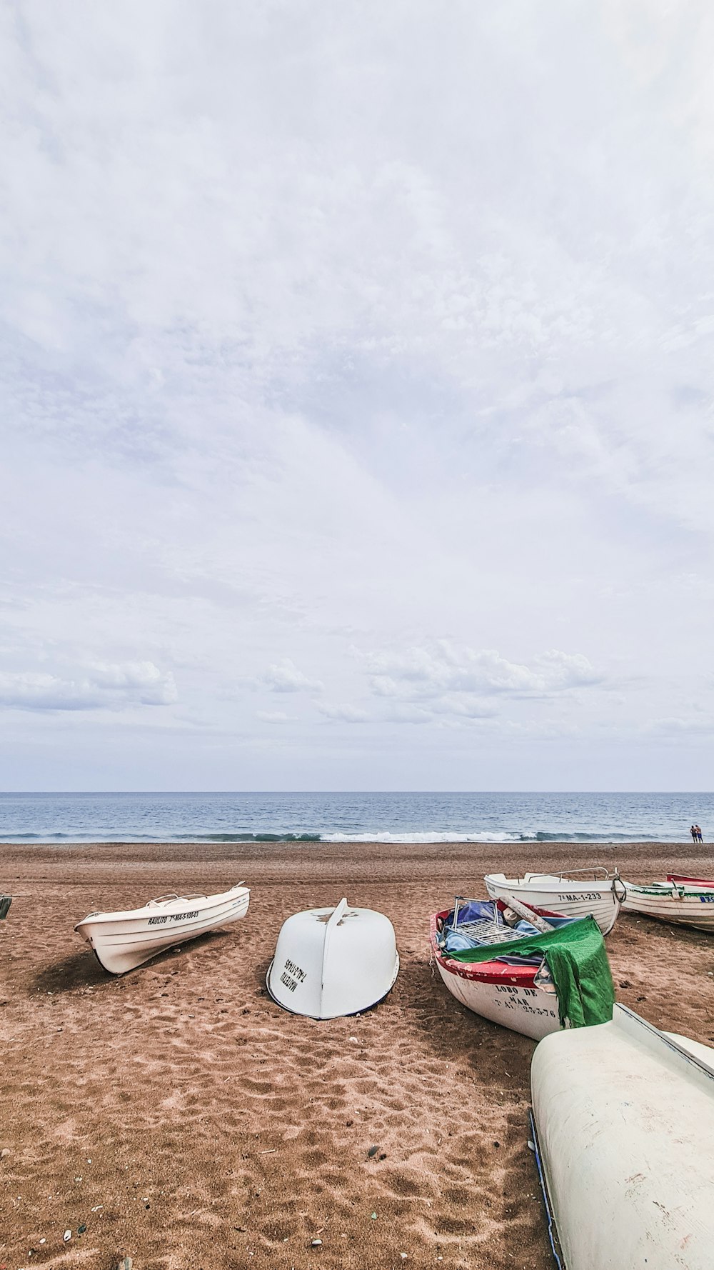 a group of boats sitting on top of a sandy beach