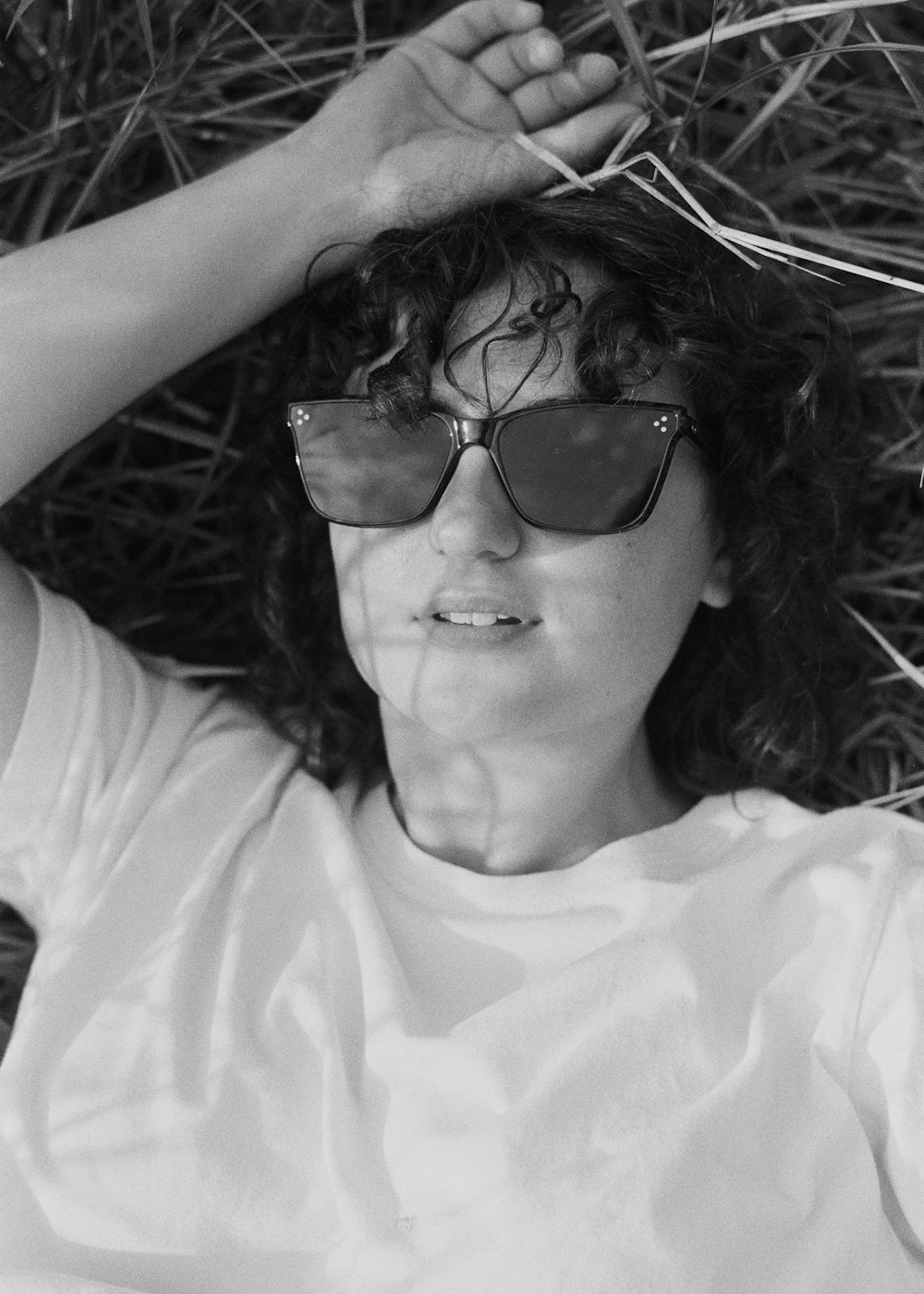 a woman laying on the ground wearing sunglasses