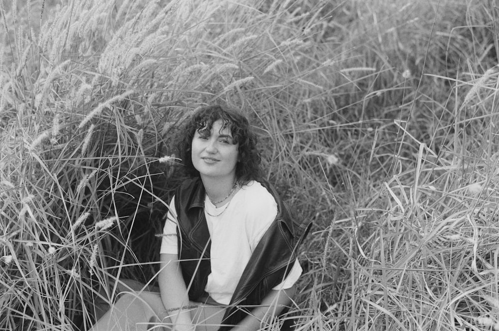 a woman sitting in a field of tall grass