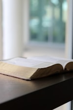 An open book resting on a rustic wooden table with a backdrop of the Pays de Retz countryside