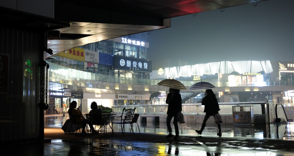 Eine Gruppe von Menschen, die mit Regenschirmen eine Straße entlang gehen