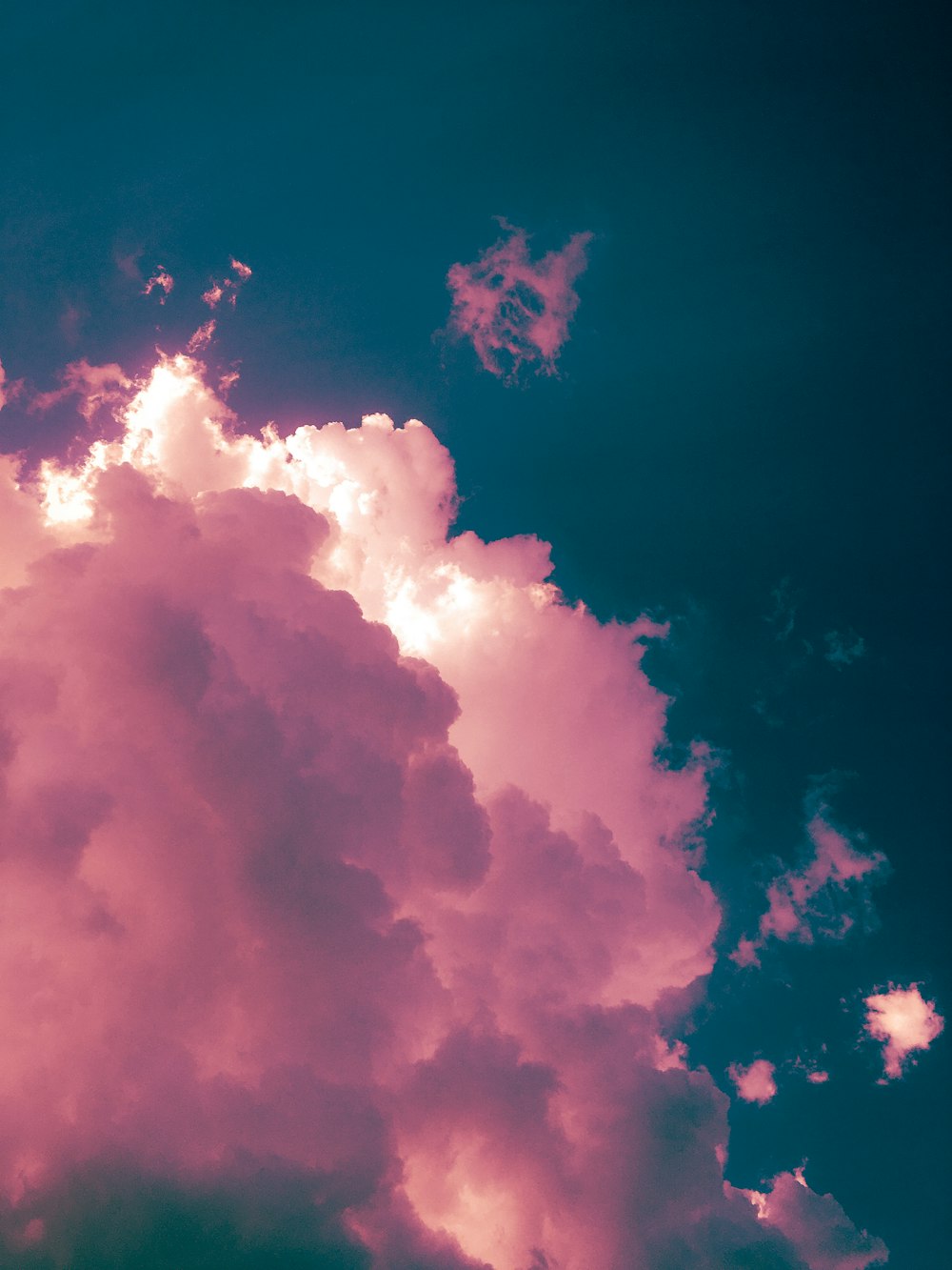 a plane flying through a cloudy blue sky