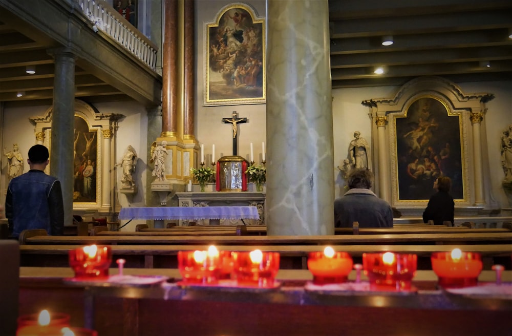 a couple of people standing in a church with candles