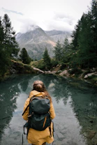 a woman with a backpack is standing in the water