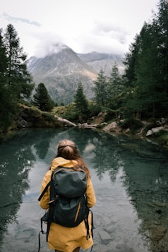 a woman with a backpack is standing in the water