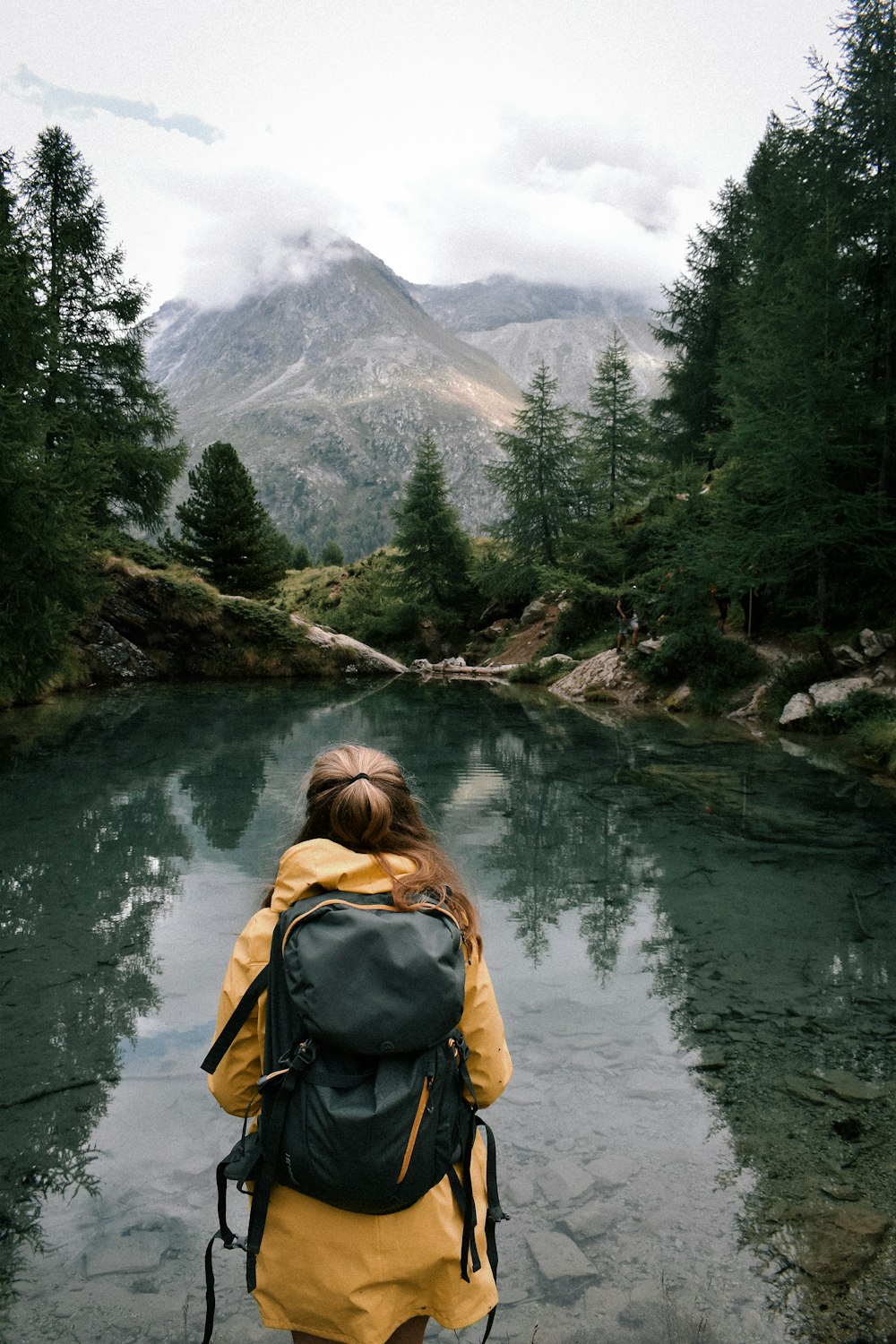 a woman with a backpack is standing in the water