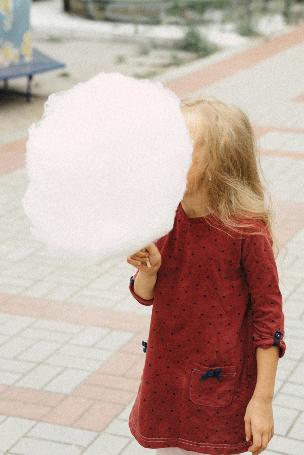 a little girl holding a large white cotton ball