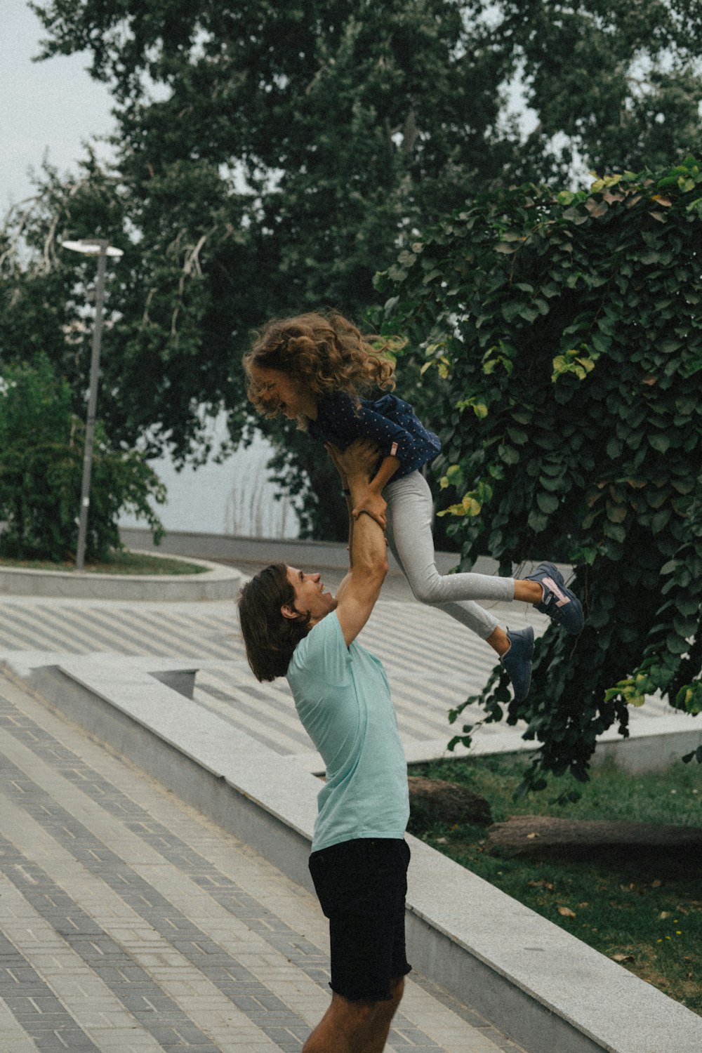 a man holding a little girl on his shoulders