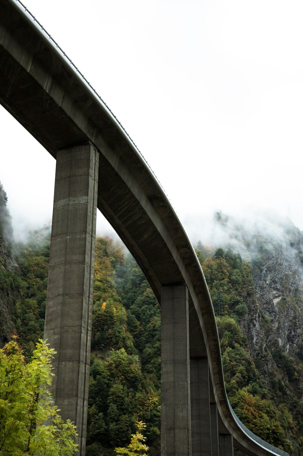 a bridge over a river with a mountain in the background