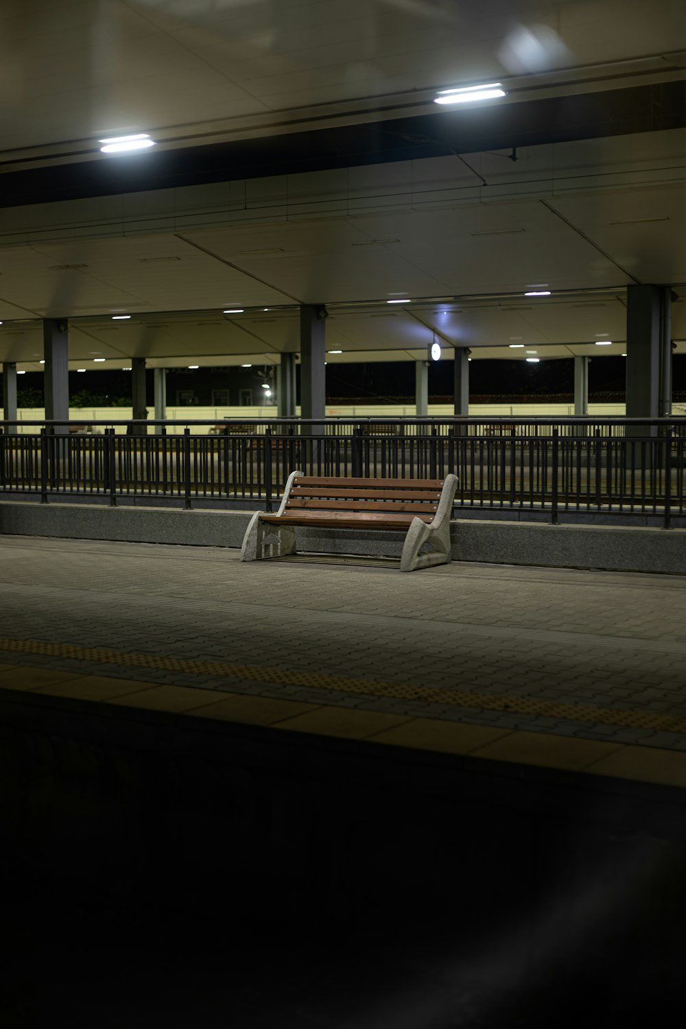 a wooden bench sitting in the middle of a train station