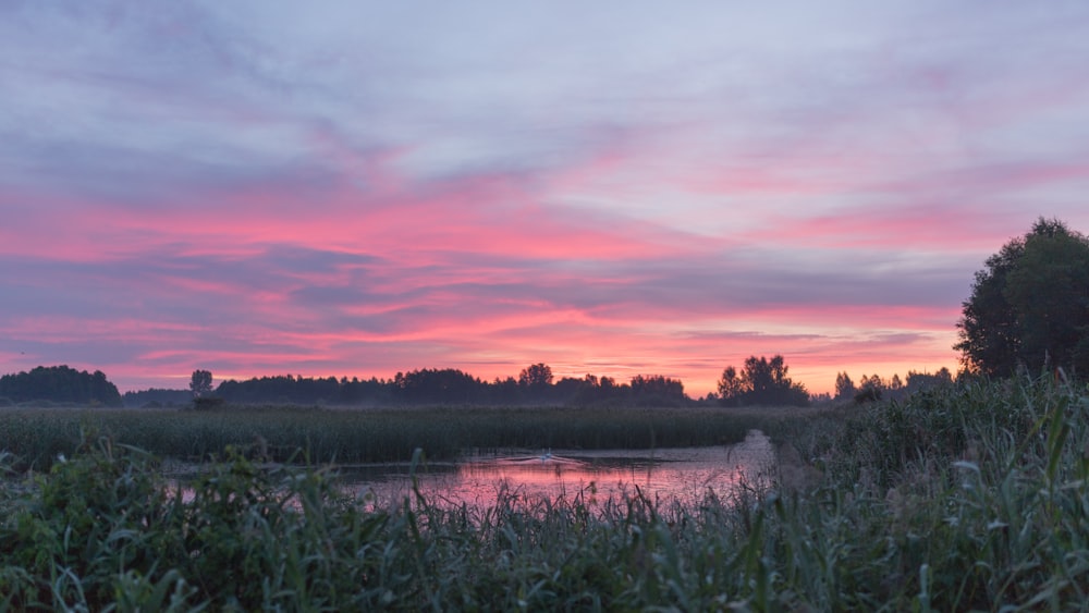 Una puesta de sol rosa y púrpura sobre un río