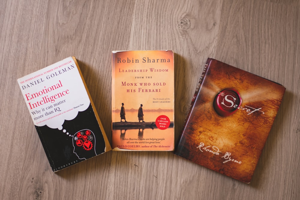 three books sitting on top of a wooden table