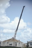 a crane is lifting a house into the air