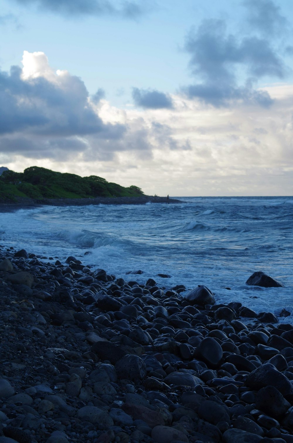 Une plage rocheuse au bord de l’océan sous un ciel nuageux