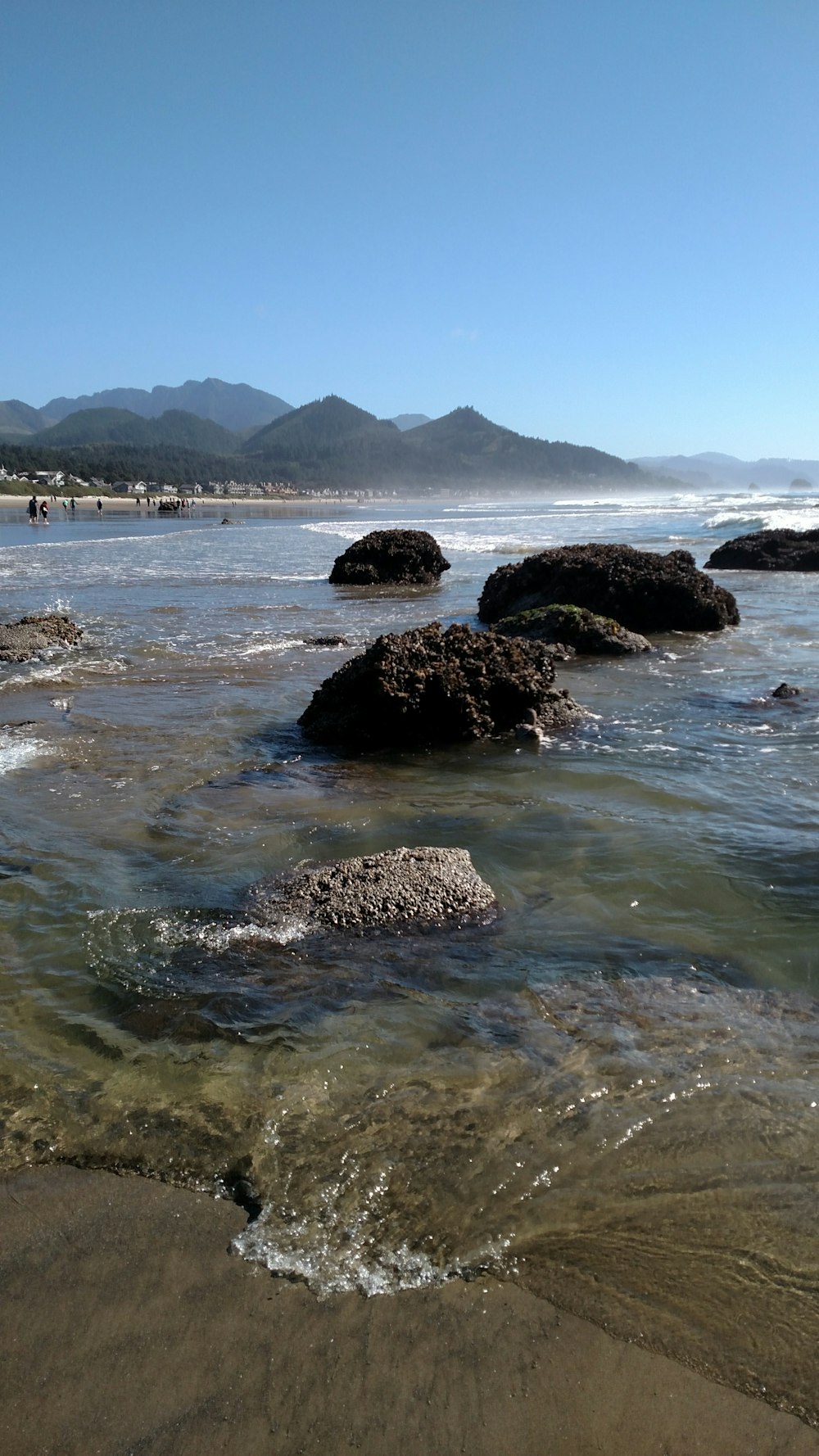 a beach with some rocks in the water